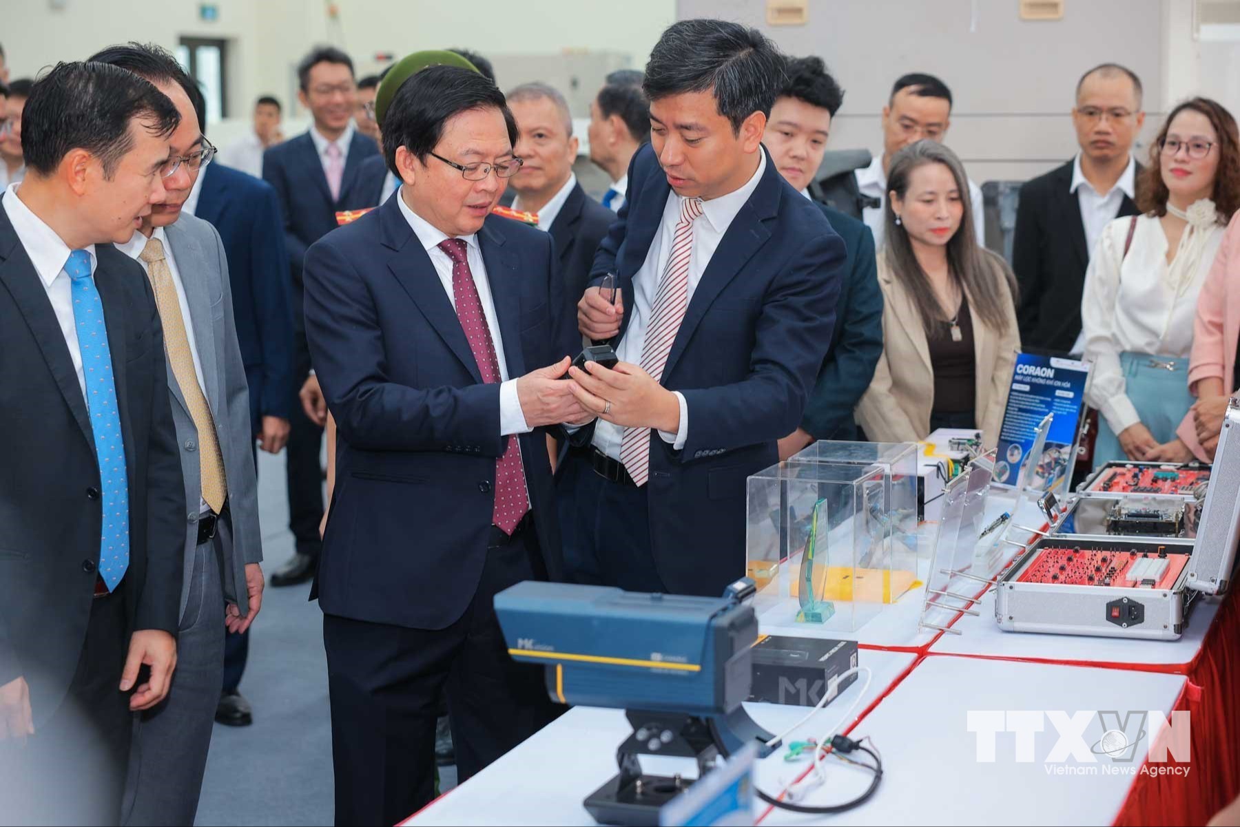Phó Thủ tướng Hồ Quốc Dũng cùng các đại biểu tham quan các sản phẩm tại Phòng thí nghiệm đóng gói và đo kiểm chip bán dẫn. (Ảnh: Hoàng Hiếu/TTXVN)